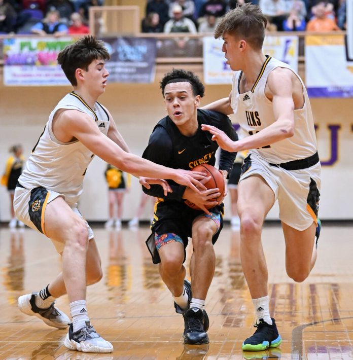 Sidney senior guard Jy Foster-Wheeler tries to keep hold of the ball while under pressure from Centerville’s Collin O’Connor, left, and Matt Wilkins, right, during a Division I district semifinal on Friday at Vandalia-Butler’s Student Activity Center. Foster-Wheeler is one of four seniors the squad will lose to graduation.