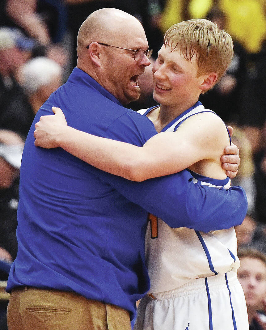 Russia’s Xavier Phlipot gets a hug from coach Spencer Cordonnier after Phlipot was pulled from the court in the final minute of Russia’s 53-38 win over Botkins in a Division IV district semifinal on Friday at Garbry Gymnasium.